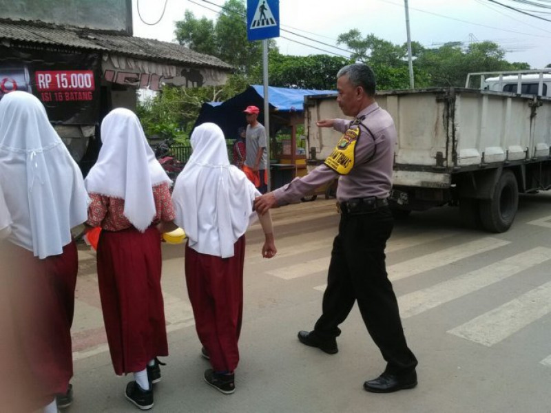 IMG-anggota-bhabinkamtibmas-polsek-benda-bantu-menyeberangkan-anak-sekolah