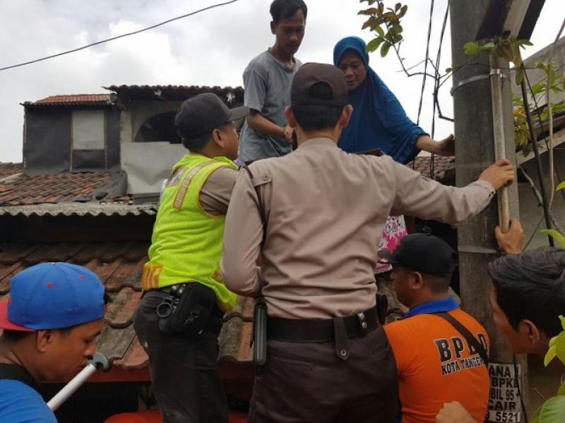 IMG-anggota-polsek-jatiuwung-evakuasi-warga-perumahan-total-persada-yang-terkena-banjir